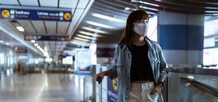 Nő maszkban üres reptéren