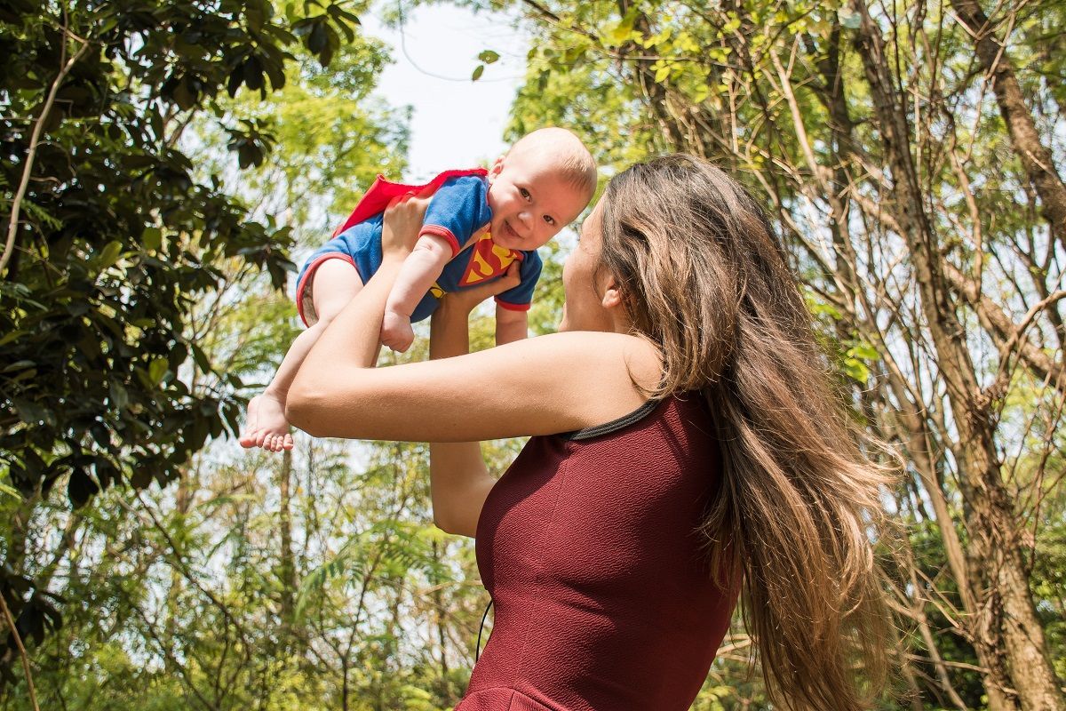 Superman jelmezes kisbabát felemel az anyukája